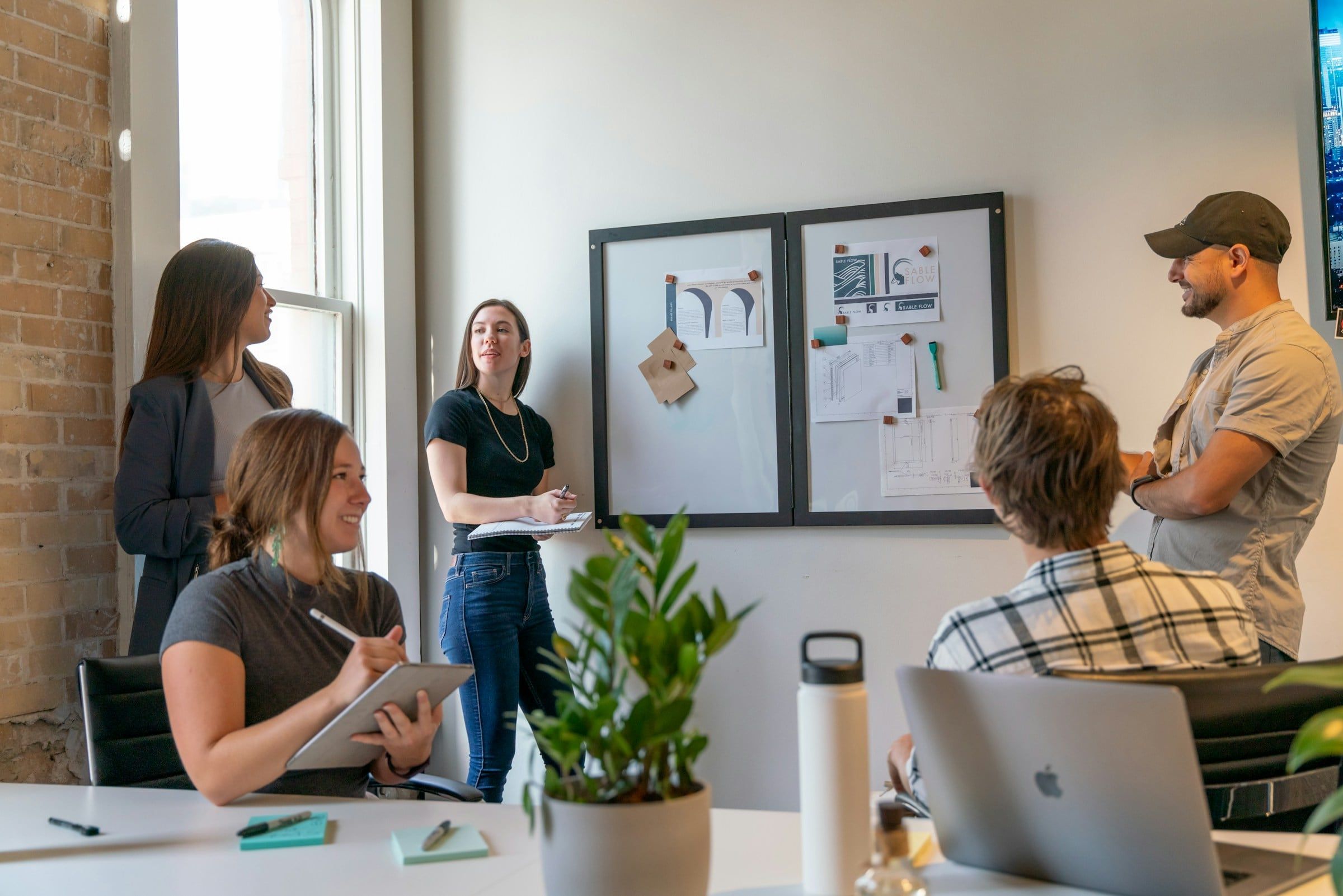 Equipo de un estudio creativo revisando su trabajo alrededor de una mesa